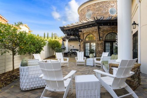 White patio furniture outside of a restaurant.