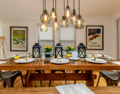 A wooden dining table with black lanterns.