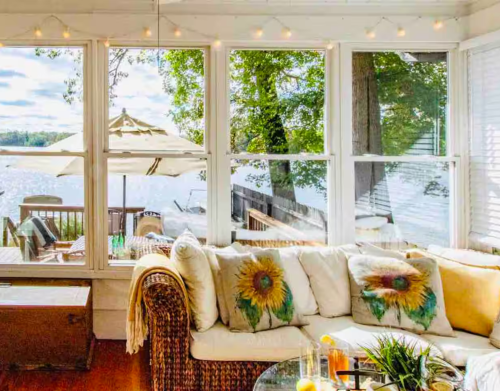 A well-lit living room overlooking a lake.