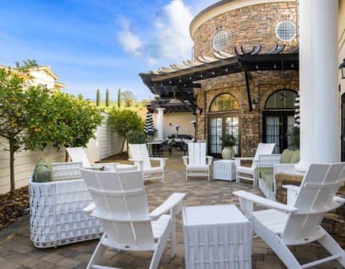 White patio furniture outside of a restaurant.