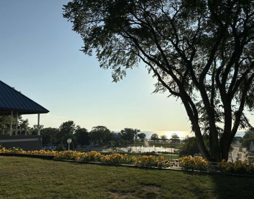 A park overlooking a splash pad and lakefront.
