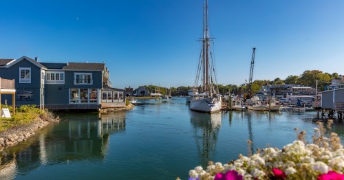 Boats float in the harbor under blue skies in Kennebunkport, Maine.