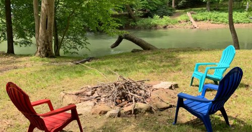 colorful adirondack chairs by a fire pit and a river during the day in buckhannon west virginia
