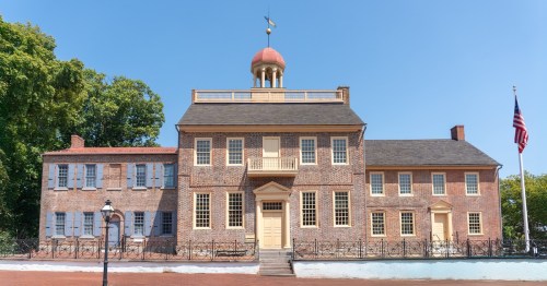 Historic brick court house museum under a blue sky in New Castle, Delaware.