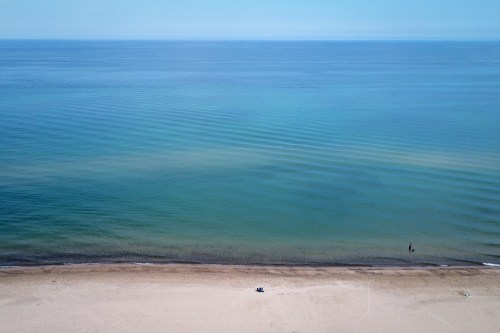 Blue Lake Michigan water with sky and beach