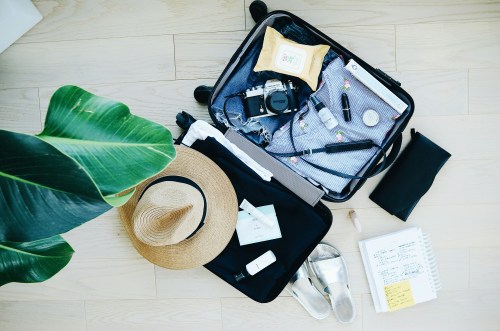 Flat lay of suitcase and travel items