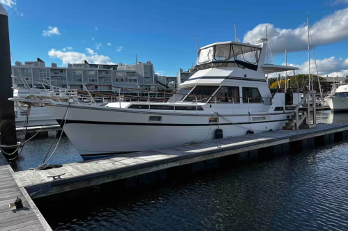 The exterior of the Carpe Diem II, Airbnb yacht in Boston, Massachusetts. The boat is docked at a pier.