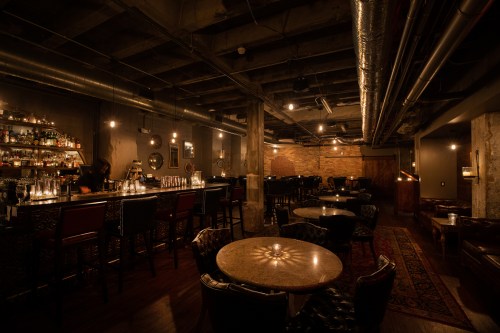 Dimly lit bar with brick walls and candlelight