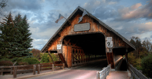 A wooden covered bridge with a dirt road in Michigan.