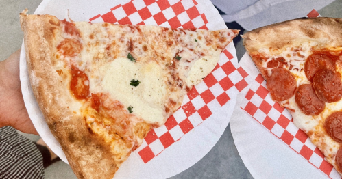 Two slices of pizza on two paper plates from Vinnie's Pies in Fort Smith, AR