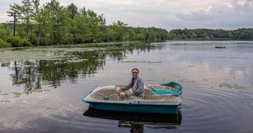A guest enjoys a pedal boat on Summit Lake, accessible from this Pennsylvania Airbnb in the Pocono Mountains.