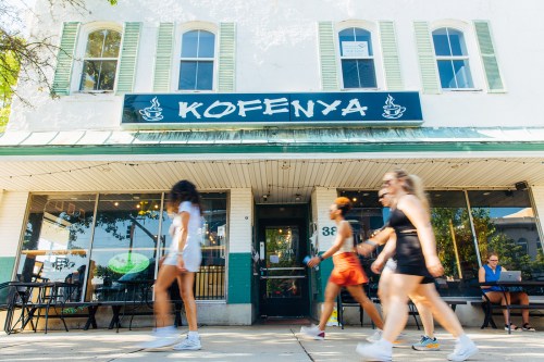 Three women walking in front of a coffee shop