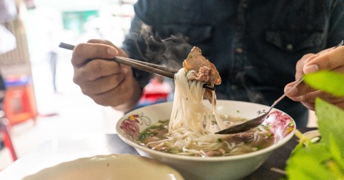 A man eating a bowl of Pho