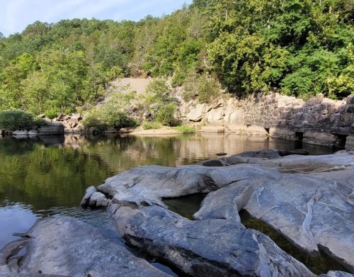 A lake surrounded by small bluffs and forest.