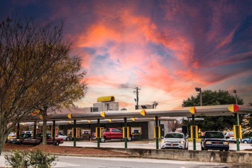 Cars at the Sonic drive-in stalls at sunset.