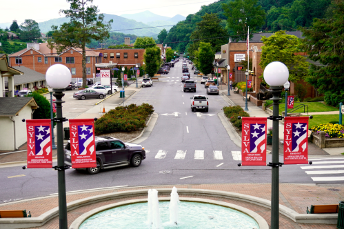Two-lane street with brick buildings on either side and mountains in the distance