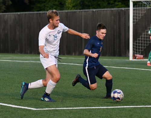 Two men are playing soccer.