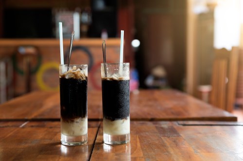 Two glasses of Vietnamese coffee on a communal table.