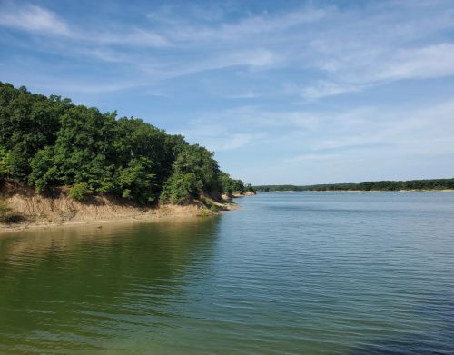A lake situated against a rocky slope with trees.