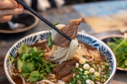 Bowl of hot pork pho with toppings.