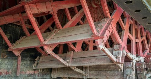 A closeup image of a red and brown wooden paddle wheel in Brownsville, Nebraska