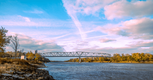 A pink and blue sunset sky over a bridge across the Missouri River in Brownsville