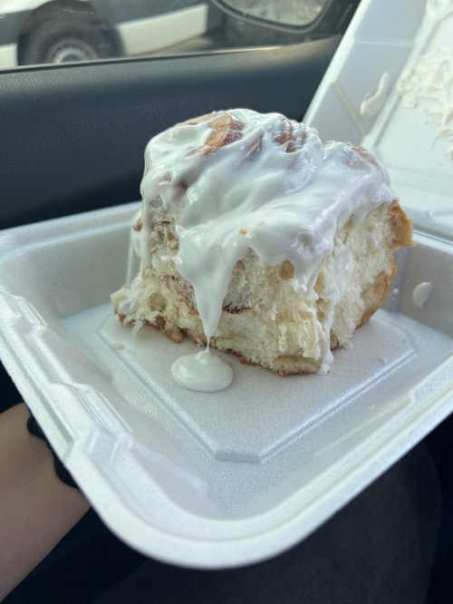 Giant cinnamon roll from The Pine Cone in a white styrofoam container