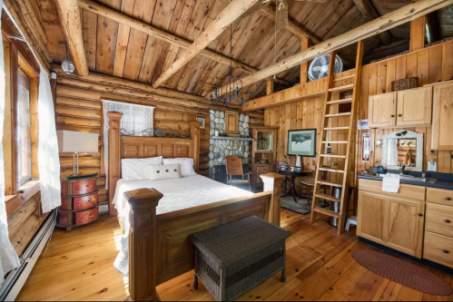 Main room with bed in log cabin in Maine