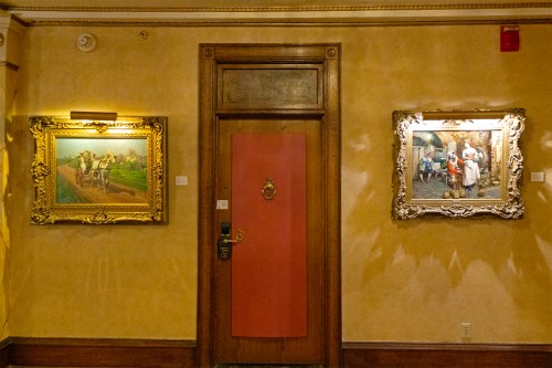 Red door with a painting on either side