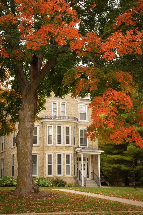 East Hall on Ripon College campus with orange and green foliage