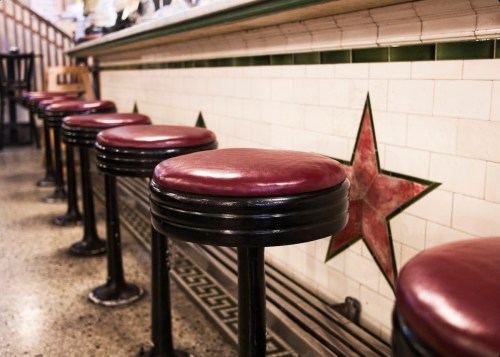 Red leather stools at an old fashioned soda shop.