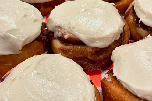 Golden brown cinnamon rolls topped with thick white icing