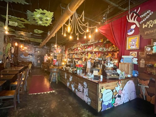 The inside of a fantasy-themed restaurant covered in handmade cartoon drawings.