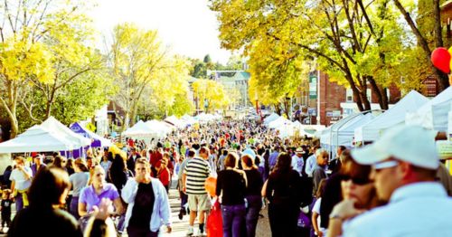 A crowd of people walking through an outdoor fest.