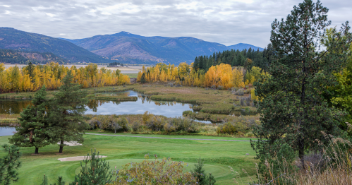 Trees covered in fall foliage surround a small pond near Bonners Ferry, Idaho.