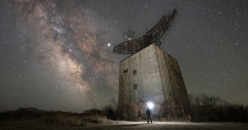 Montauk night sky over the large, abandoned Camp Hero radar tower and buildings.