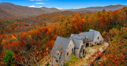 Exterior of an Airbnb castle surrounded by fall foliage and a hint of blue skies