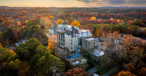 1886 Crescent Hotel & Spa in Eureka Springs, Arkansas from above on a fall day, surrounded by foliage