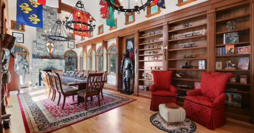 The Great Hall within a castle-themed Airbnb in Monroe, Washington, complete with a large table, suits of armor, and shelves covered in swords.