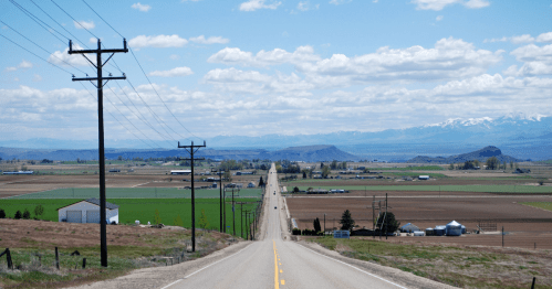 Looking down a long road toward a small town in Idaho.