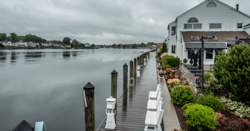 A waterfront view of a white building next to a pier in Mystic, Connecticut.