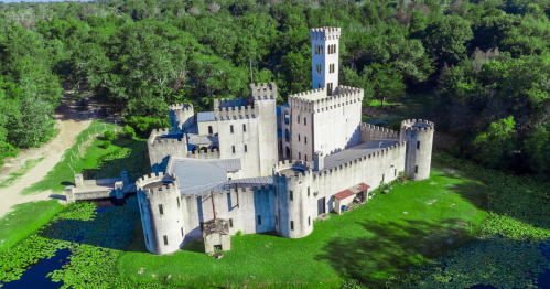 Aerial shot of Newman’s Castle in Texas surrounded by forest and moat with lily pads.