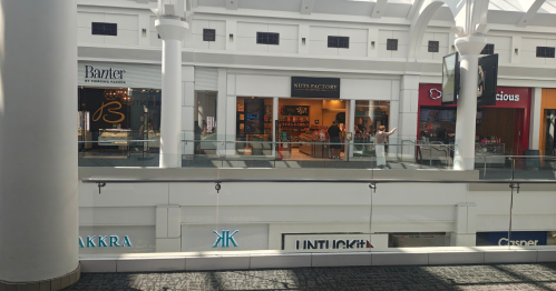 A view across the mall atrium, with the focus on a storefront named "Nuts Factory".