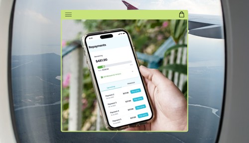 Hand holding phone with airfare booking platform and scenic view in the background