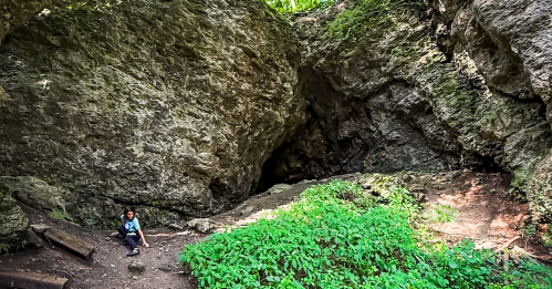 A child playing below the rocky bluffs at Pictured Rocks County Park, Iowa