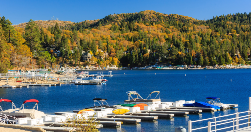 Boats sit out on Lake Arrowhead while the surrounding mountain is transformed with fall foliage.
