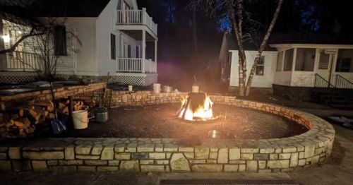 A fish boil fire in front of a white building.