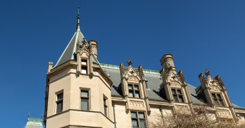 Top of Biltmore Estate against a bright blue background in Asheville NC