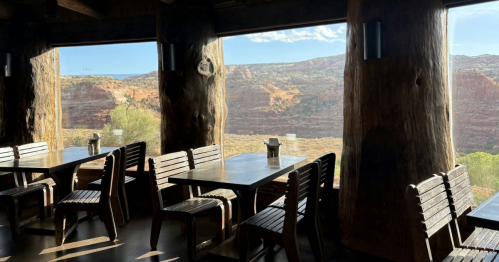 A table and chairs in a cafe set against large windows.