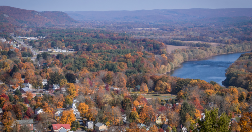 bird's eye view of the mountain town of milford and a body of water surrounded by fall colors in PA